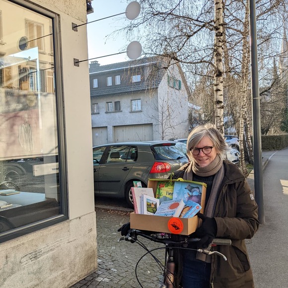 Buchhändlerin vor Schaufenster